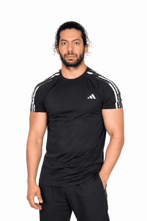 Man wearing a black Adidas sports outfit on a white background