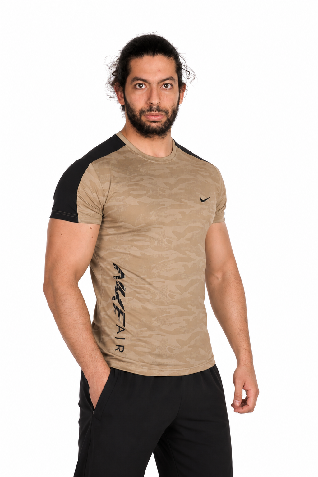 Man wearing a beige  Nike athletic shirt with sleeves and black pants on a background