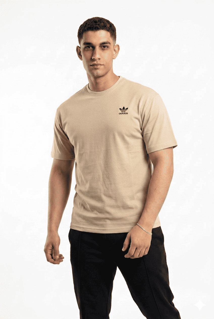 Man wearing a beige Adidas t-shirt on a background
