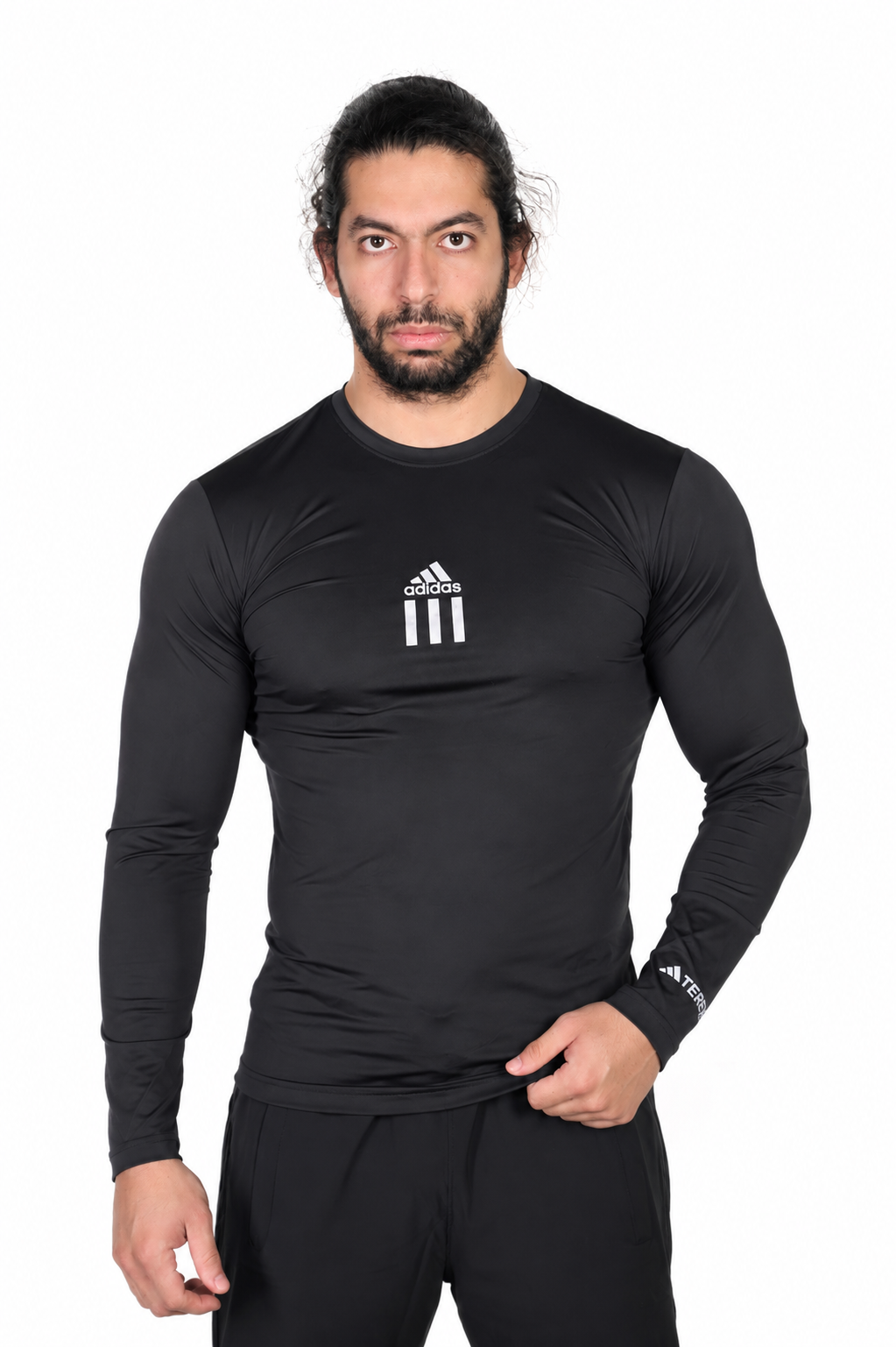 Man wearing a black athletic long-sleeve shirt with Adidas logo on a background