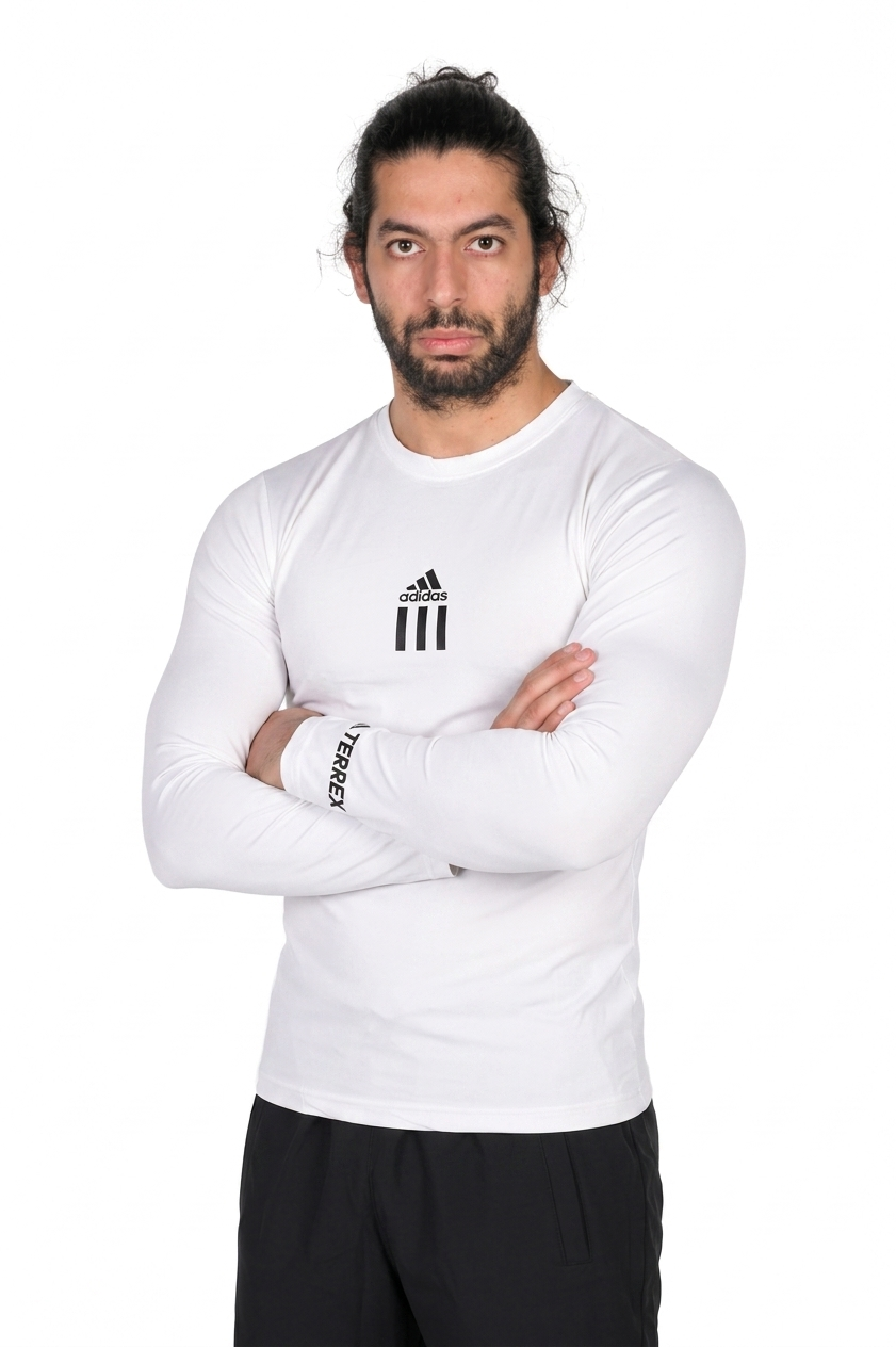 Man wearing a white Adidas long-sleeve shirt with arms crossed on a white background